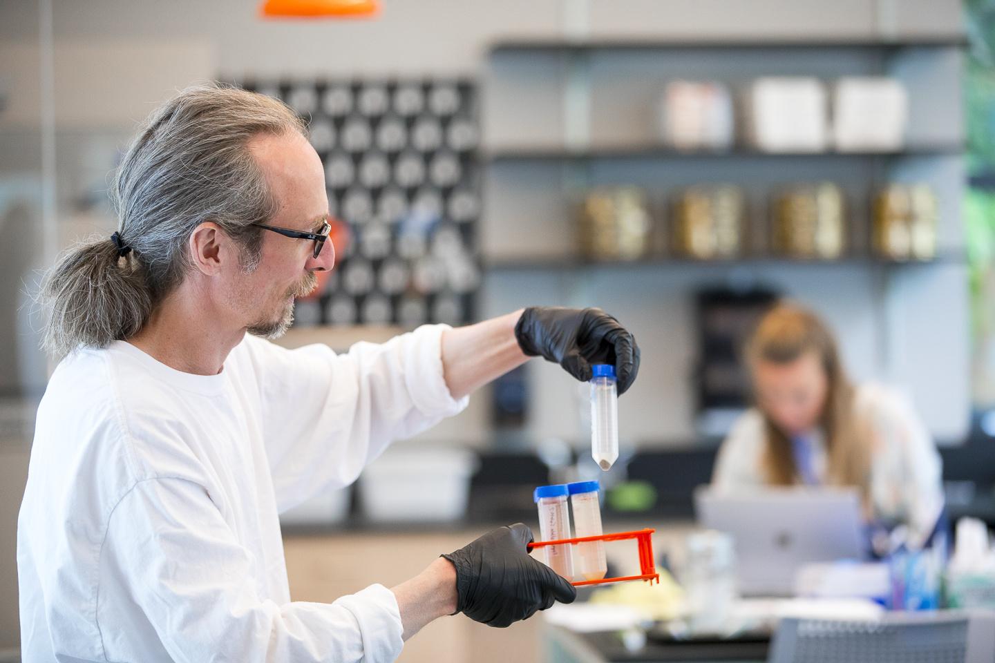 Phil Camill in classroom holding science tube