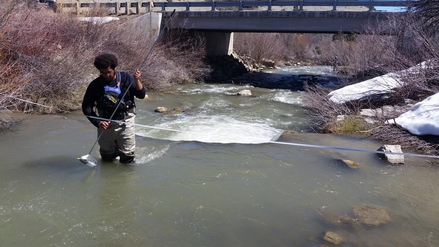 Jabari Jones standing in water collecting samples